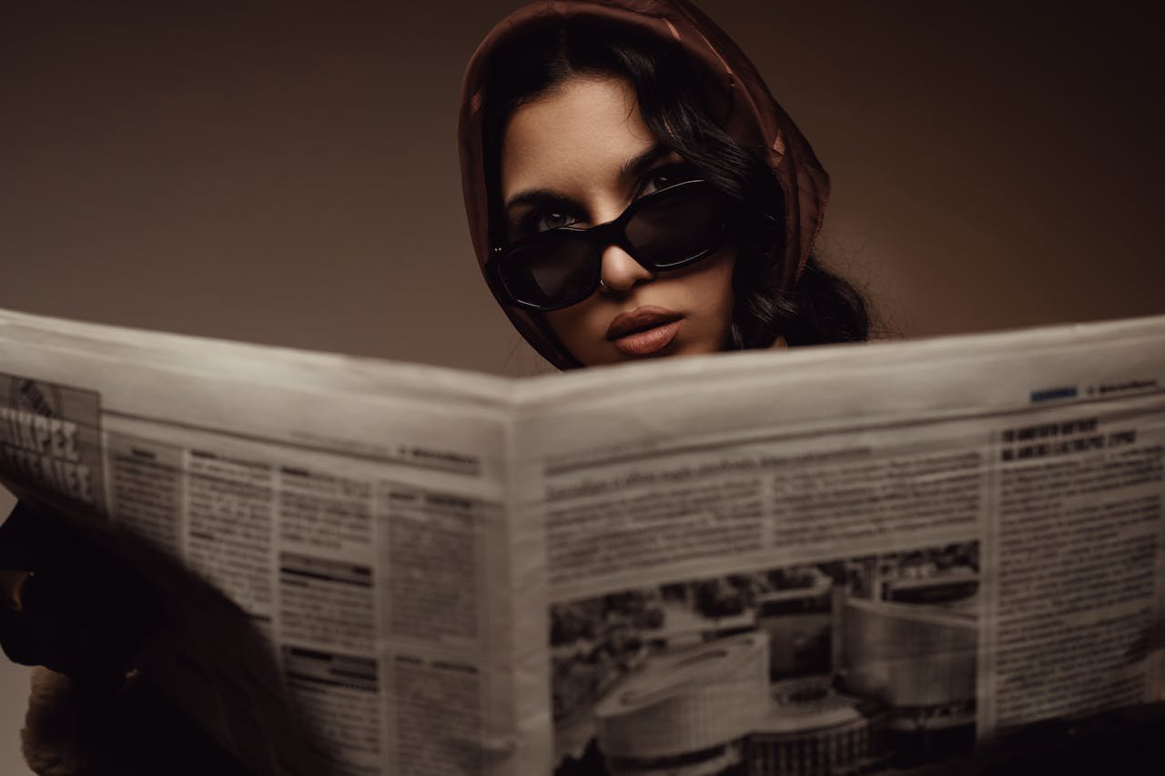 stylish-woman-reading-newspaper-in-sunglasses-29775638